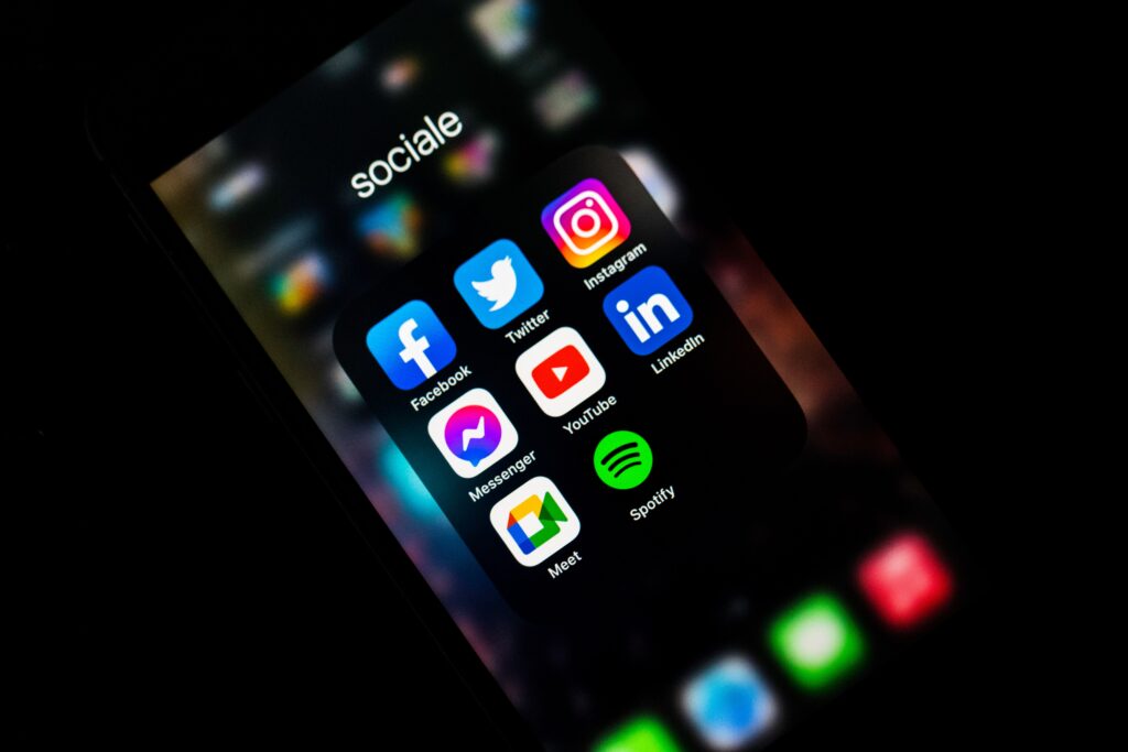 celular de social media com menu aberto mostrando vários aplicativos como Twitter, Facebook e Instagram