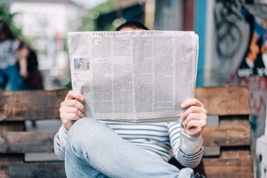 homem lendo jornal, notícia interessante