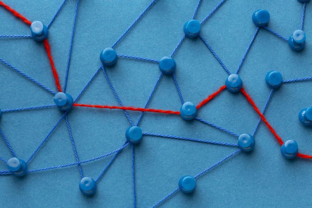 Emaranhado de fios azuis com um fio vermelho passando no meio, metáfora de linking building